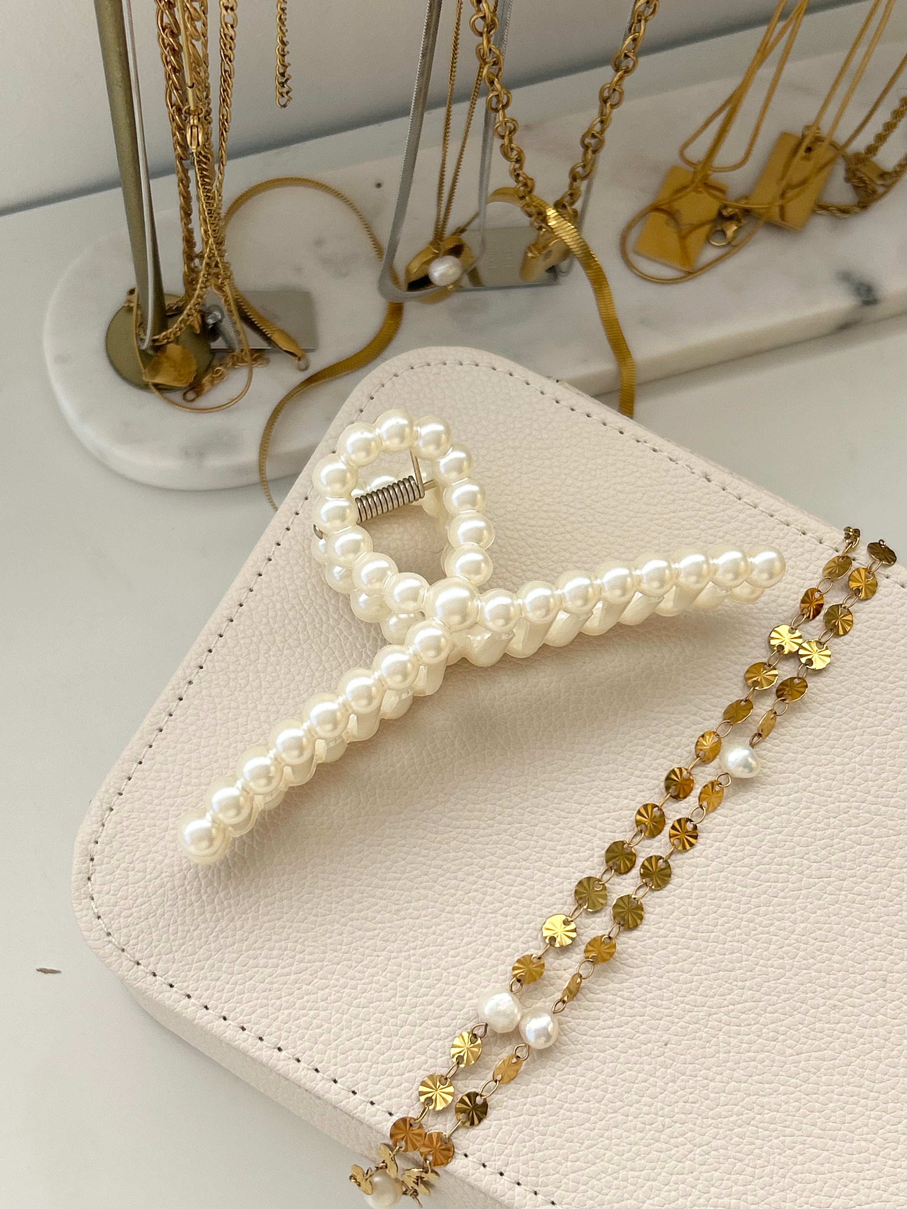 Pearl hair claw on jewellery box and gold jewellery